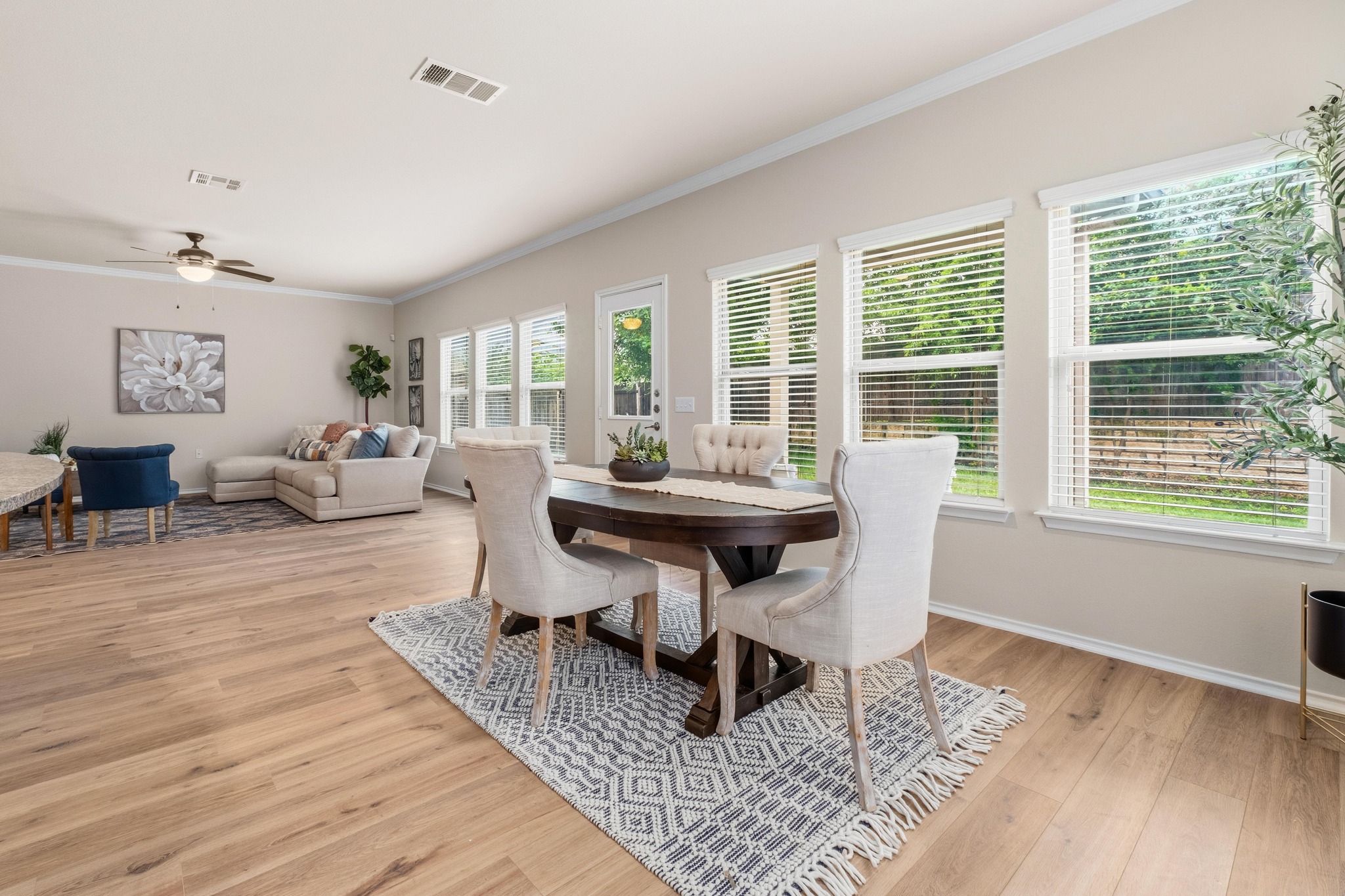 10124 Pinnacle Crest Loop Austin, TX 78747 - Photo 13 of 31 Open-concept living space featuring wood-finish flooring, multiple windows providing natural light, crown molding, and a ceiling fan