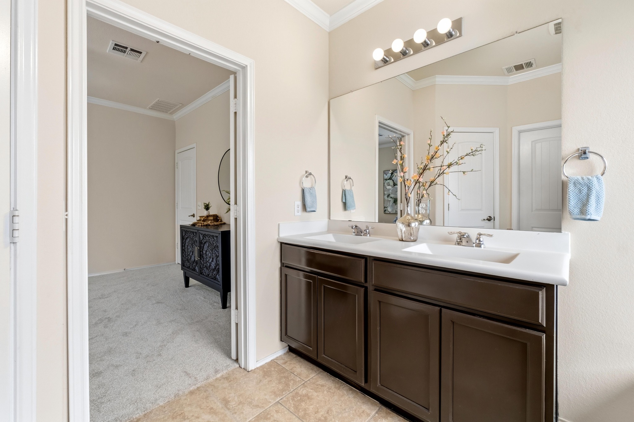 10124 Pinnacle Crest Loop Austin, TX 78747 - Photo 18 of 31 Bathroom vanity featuring dual sinks, a spacious counter, and a large mirror with integrated lighting