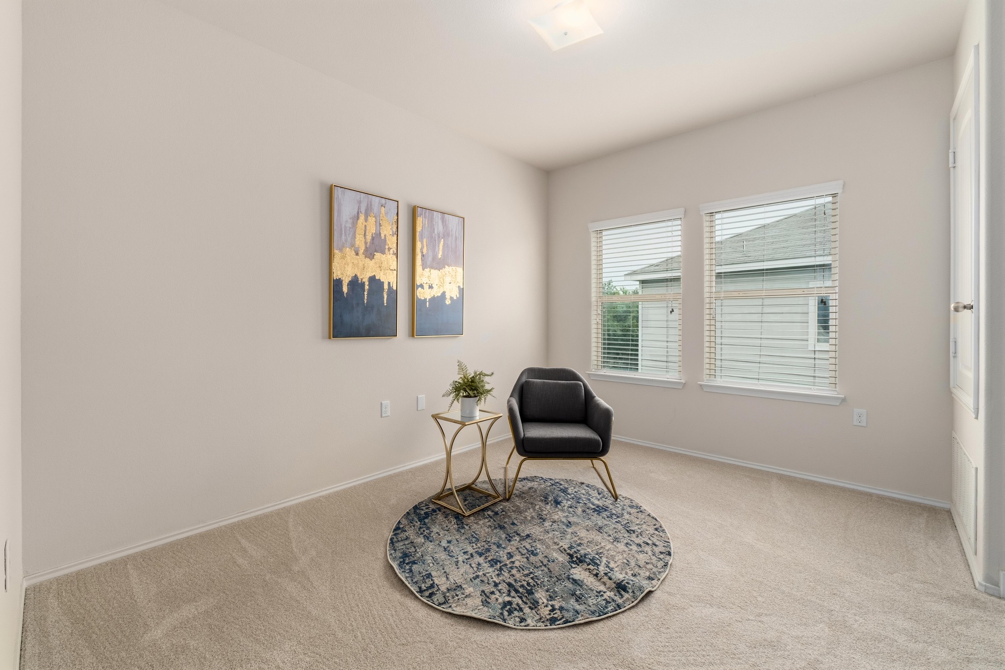 10124 Pinnacle Crest Loop Austin, TX 78747 - Photo 20 of 31 Neutral-toned walls and plush carpet flooring define this space, featuring two windows with horizontal blinds
