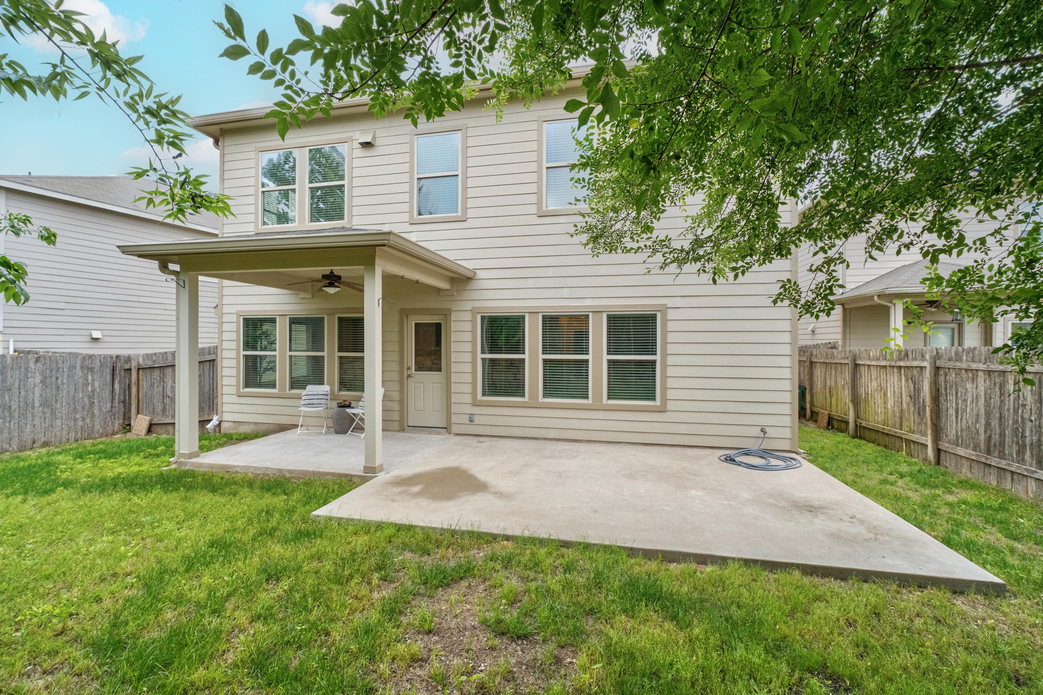 10124 Pinnacle Crest Loop Austin, TX 78747 - Photo 28 of 31 Rear exterior featuring a covered patio, additional concrete pad, and a fenced yard