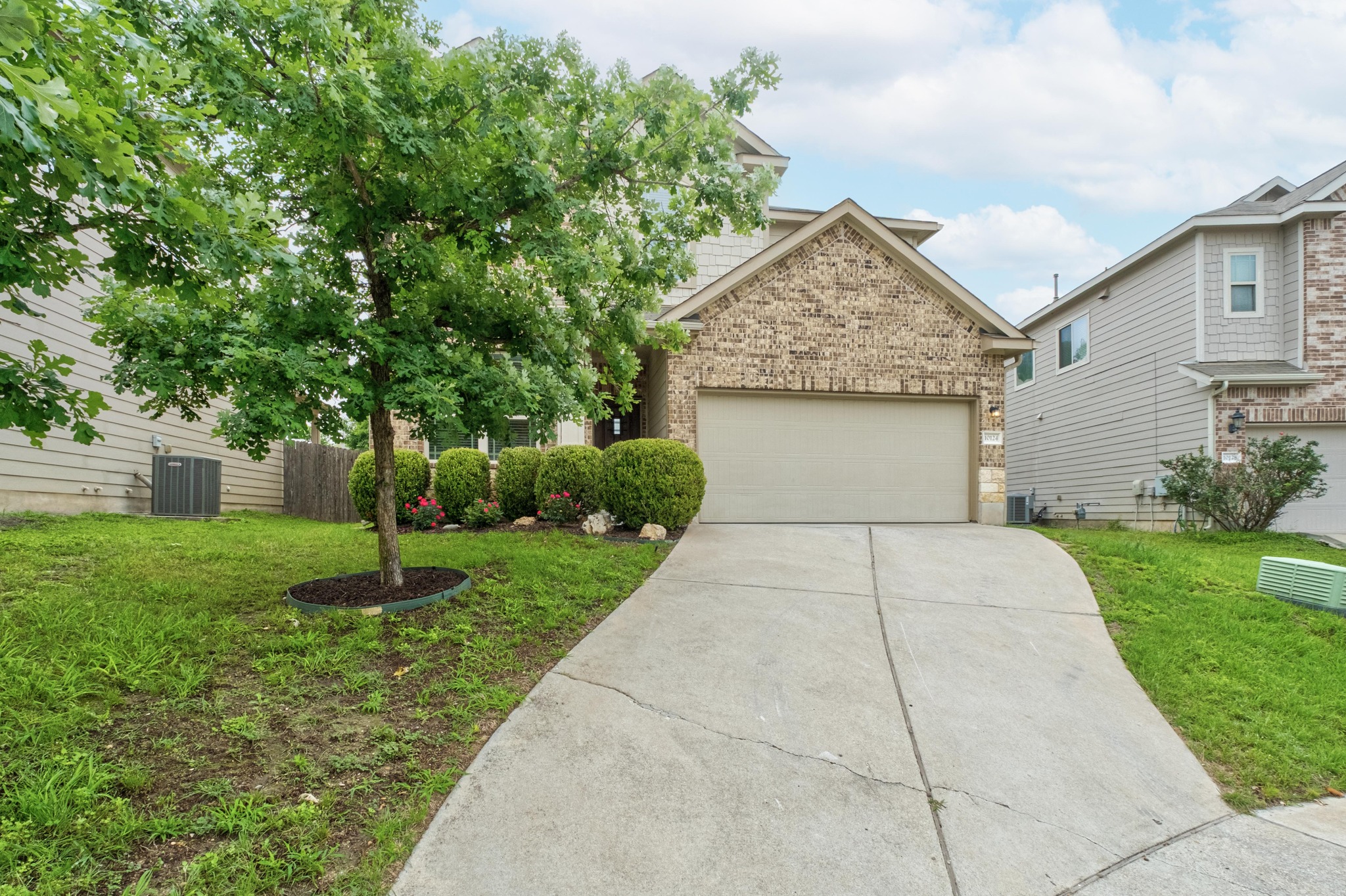 10124 Pinnacle Crest Loop Austin, TX 78747 - Photo 5 of 31 Brick-front exterior with an attached garage and concrete driveway