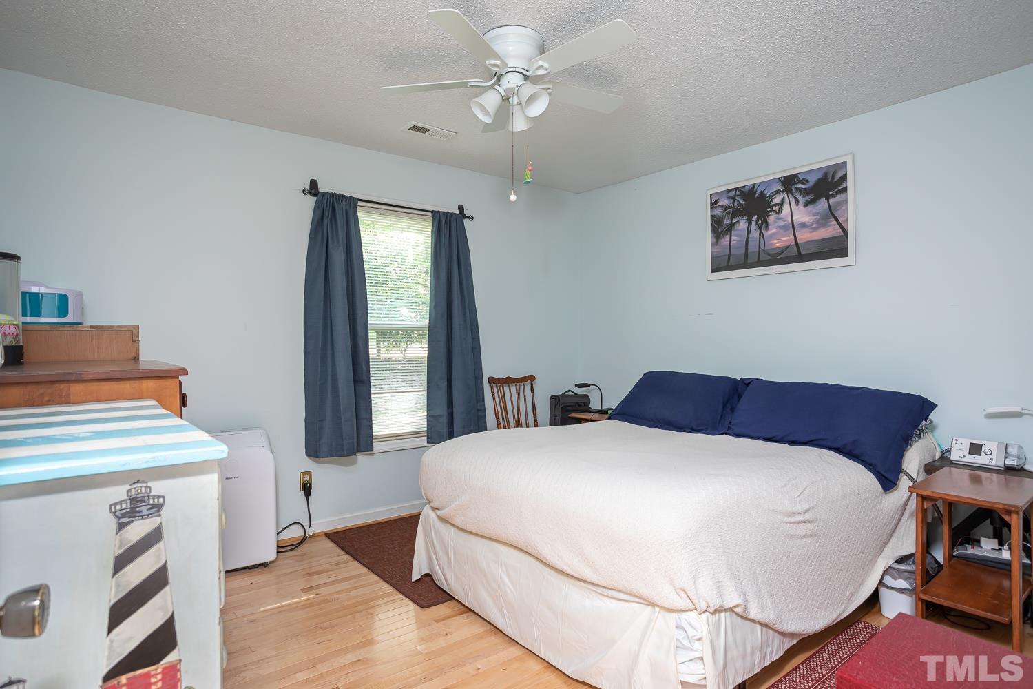 14401 Possum Track Road Raleigh, NC 27614 - Photo 14 of 30 a bedroom with a bed and a chandelier