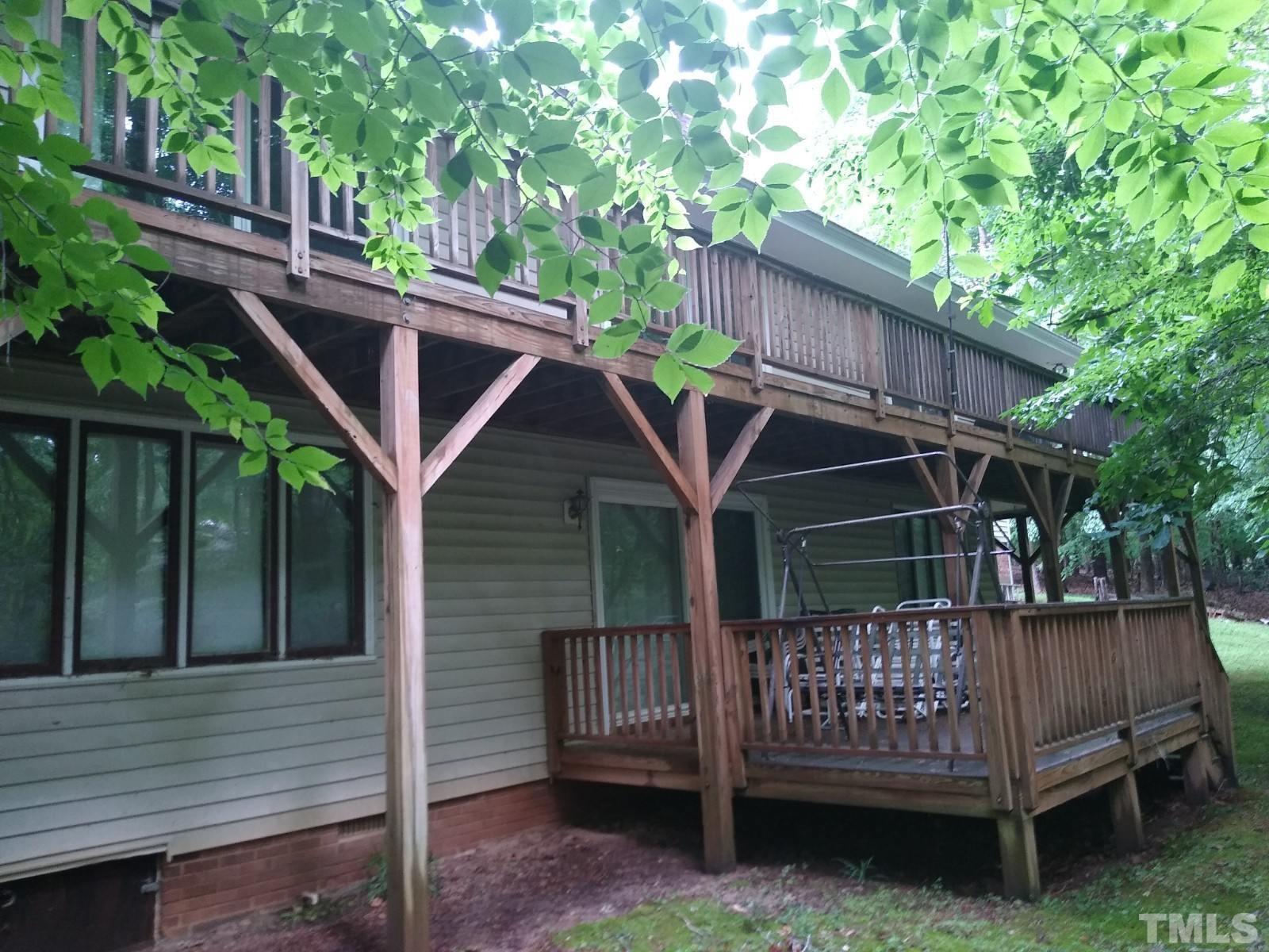 14401 Possum Track Road Raleigh, NC 27614 - Photo 3 of 30 a view of a wooden house with a deck and a yard