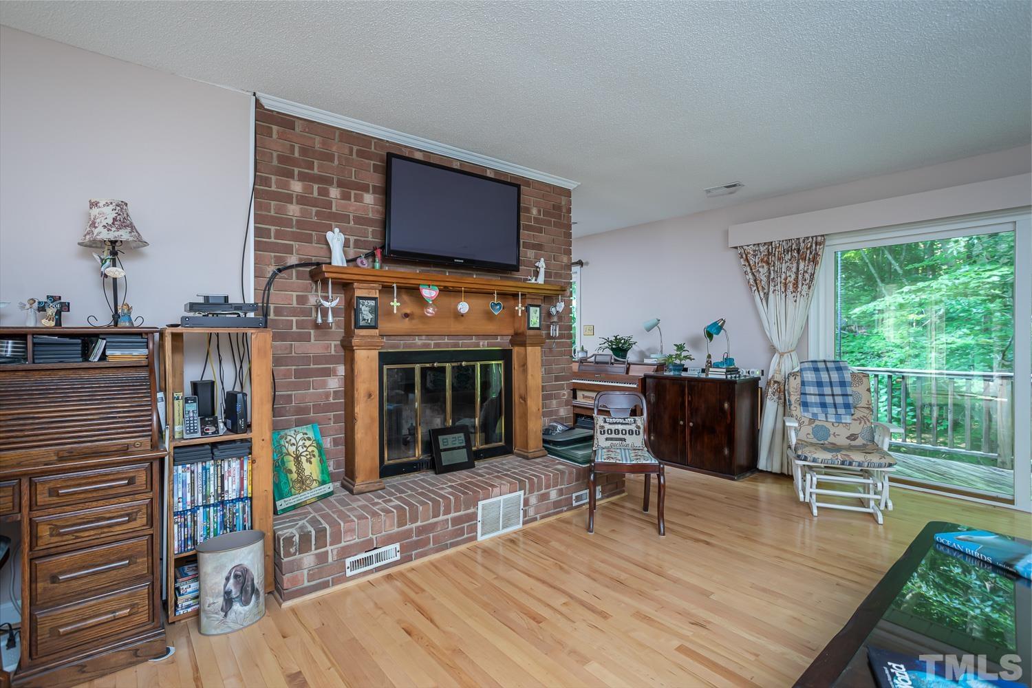 14401 Possum Track Road Raleigh, NC 27614 - Photo 5 of 30 a living room with furniture a fireplace and a flat screen tv