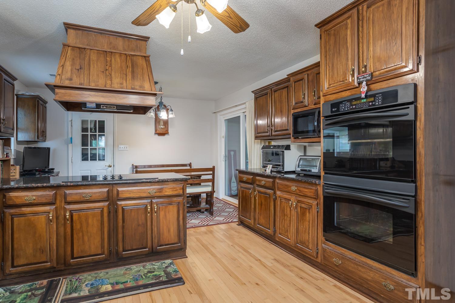 14401 Possum Track Road Raleigh, NC 27614 - Photo 7 of 30 a kitchen with stainless steel appliances granite countertop a stove sink and cabinets