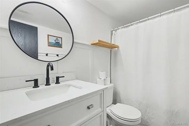 a bathroom with a toilet a sink and a mirror