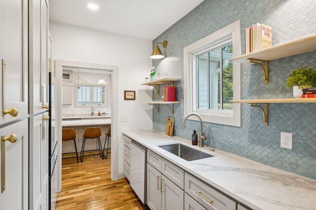 a kitchen with stainless steel appliances granite countertop a stove a sink and white cabinets