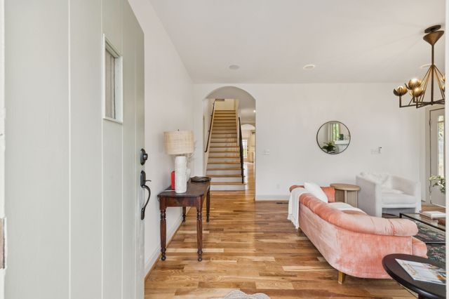 a living room with furniture flowers and a window