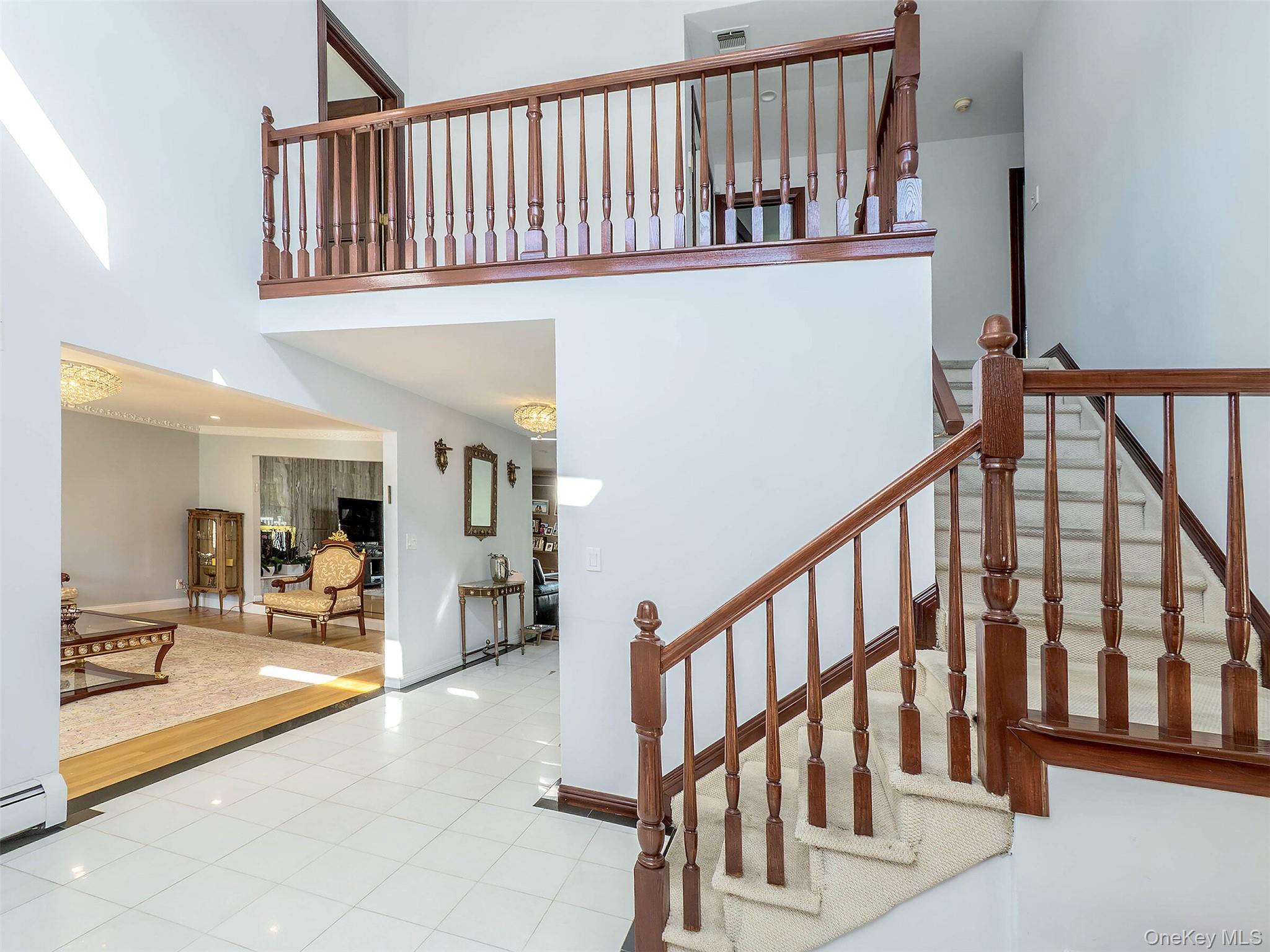 32 Carriage Road Great Neck, NY 11024 - Photo 17 of 33 a view of staircase with lots of frames and frames on wall