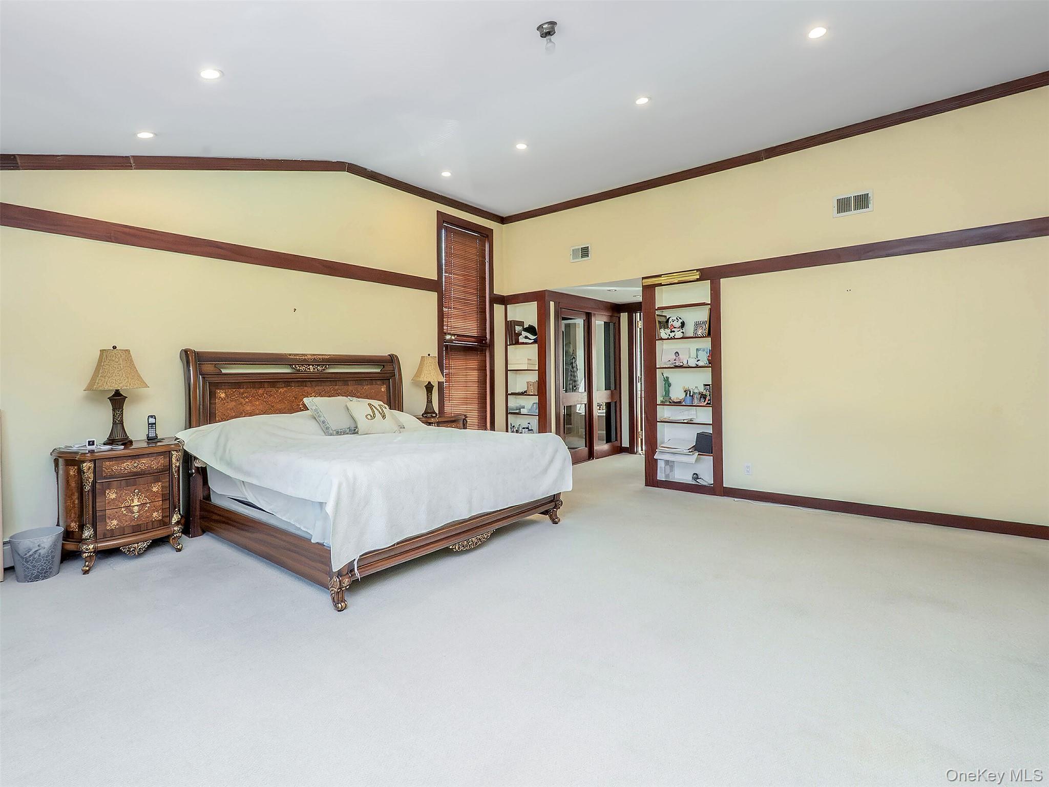 32 Carriage Road Great Neck, NY 11024 - Photo 19 of 33 a bedroom with a bed and a chandelier