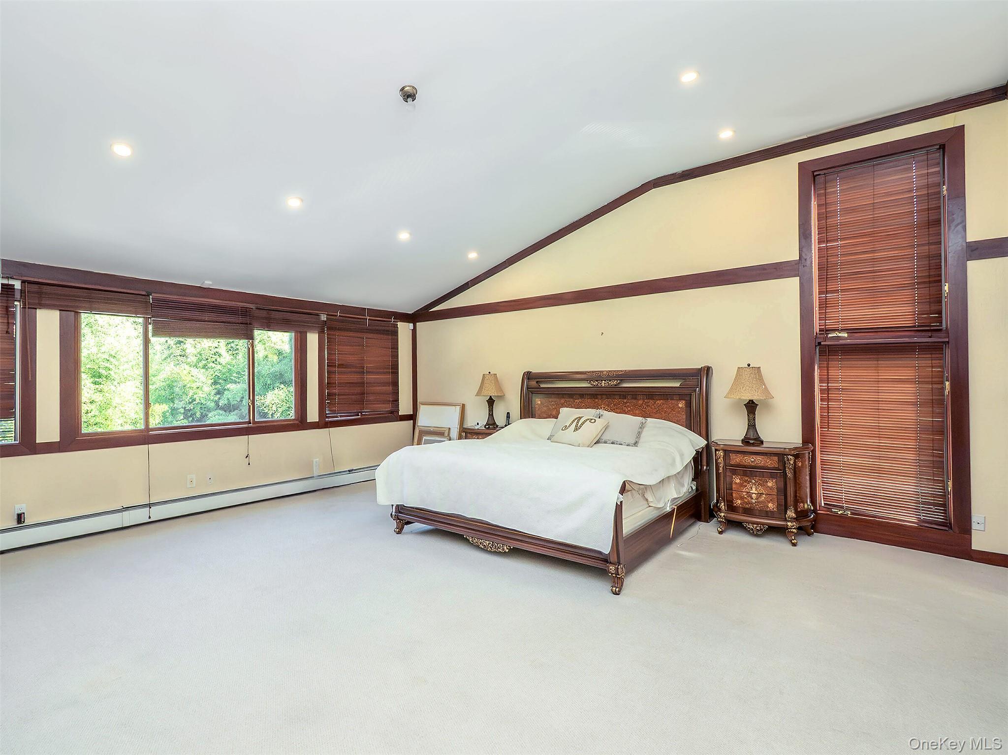 32 Carriage Road Great Neck, NY 11024 - Photo 21 of 33 a spacious bedroom with a large bed and a large window
