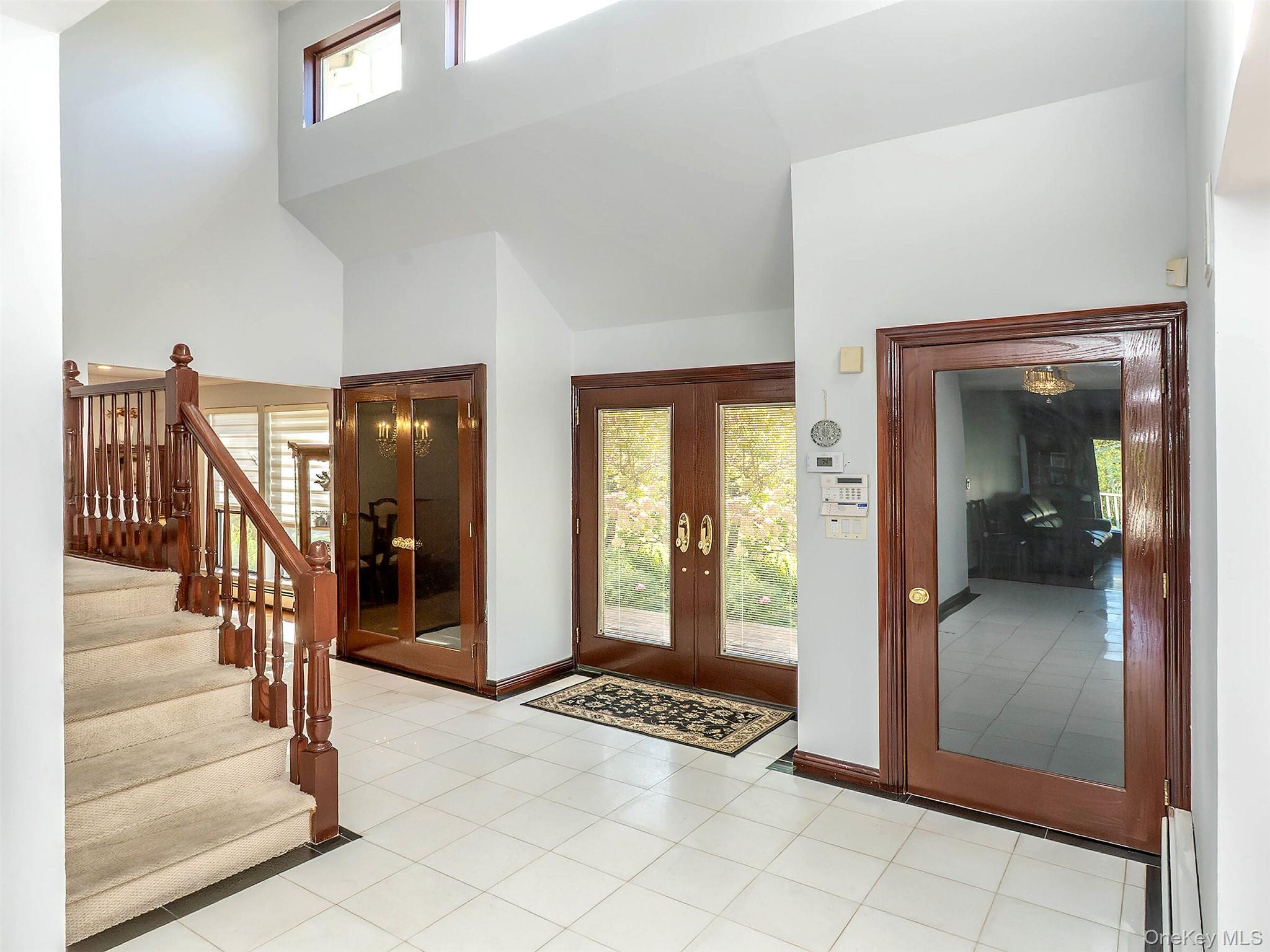 32 Carriage Road Great Neck, NY 11024 - Photo 3 of 33 a view of a hallway with wooden floor and livingroom with furniture