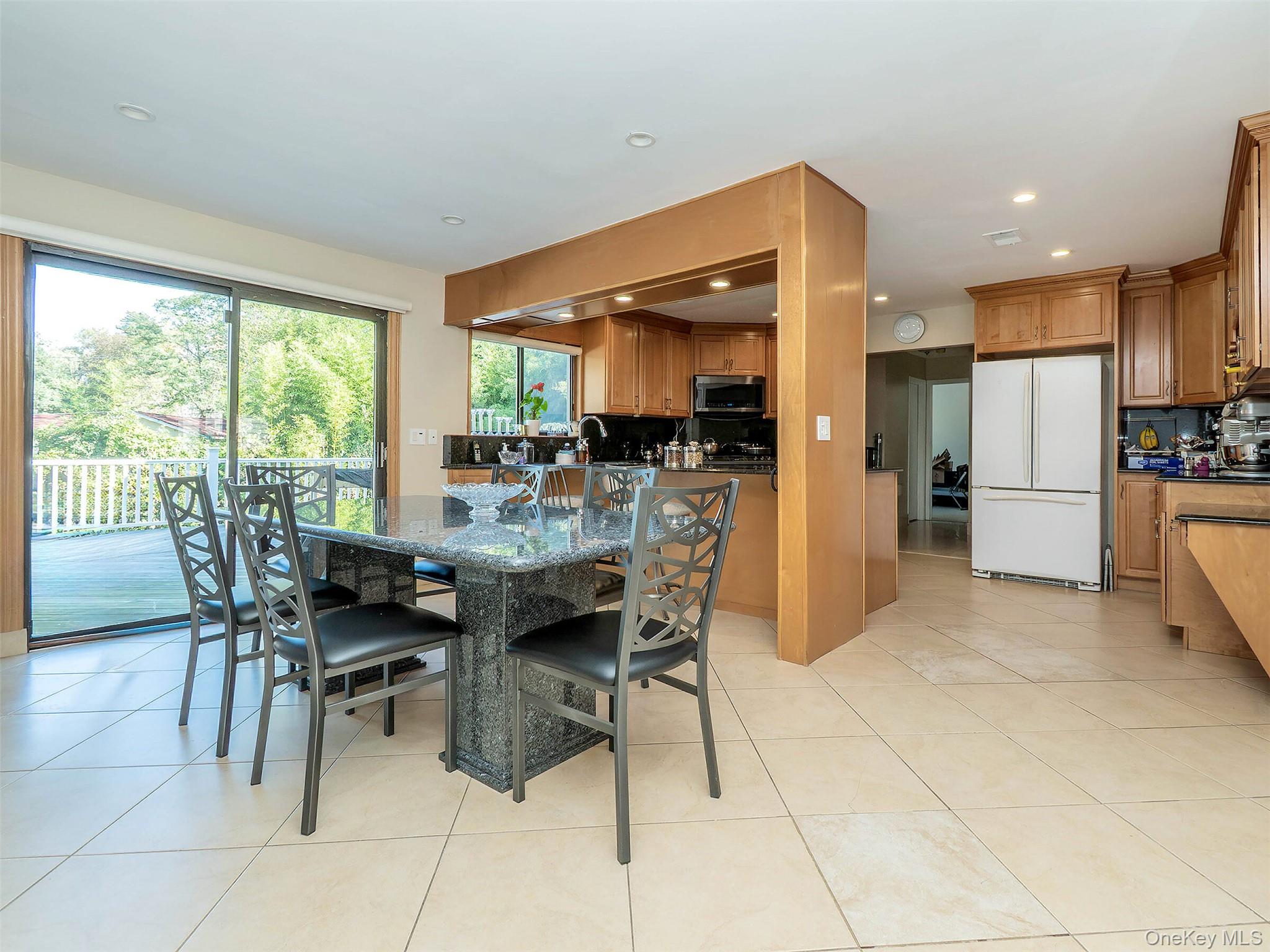 32 Carriage Road Great Neck, NY 11024 - Photo 6 of 33 a kitchen with stainless steel appliances kitchen island granite countertop a table and chairs in it