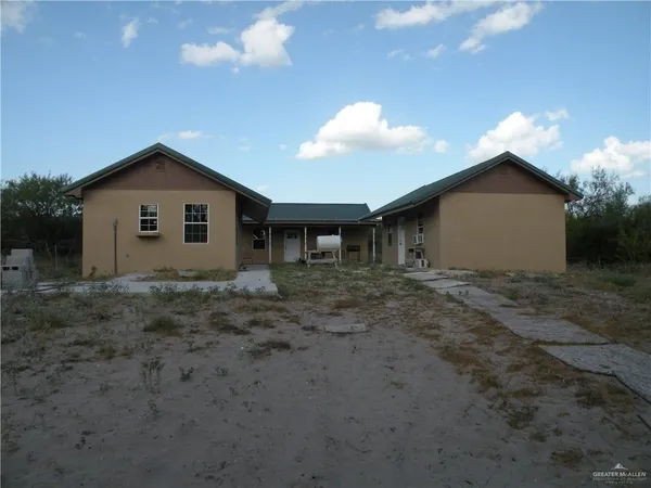 a view of a house with a backyard