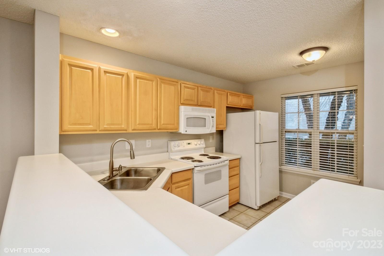 8334 Rudolph Road Charlotte, NC 28216 - Photo 2 of 31 a kitchen with stainless steel appliances a refrigerator a sink a stove and white cabinets