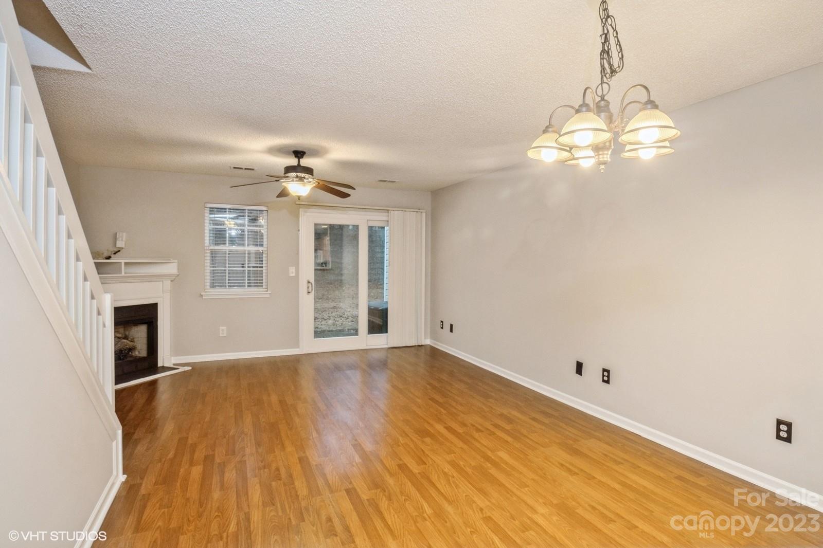 8334 Rudolph Road Charlotte, NC 28216 - Photo 4 of 31 a view of a livingroom with wooden floor a ceiling fan and windows