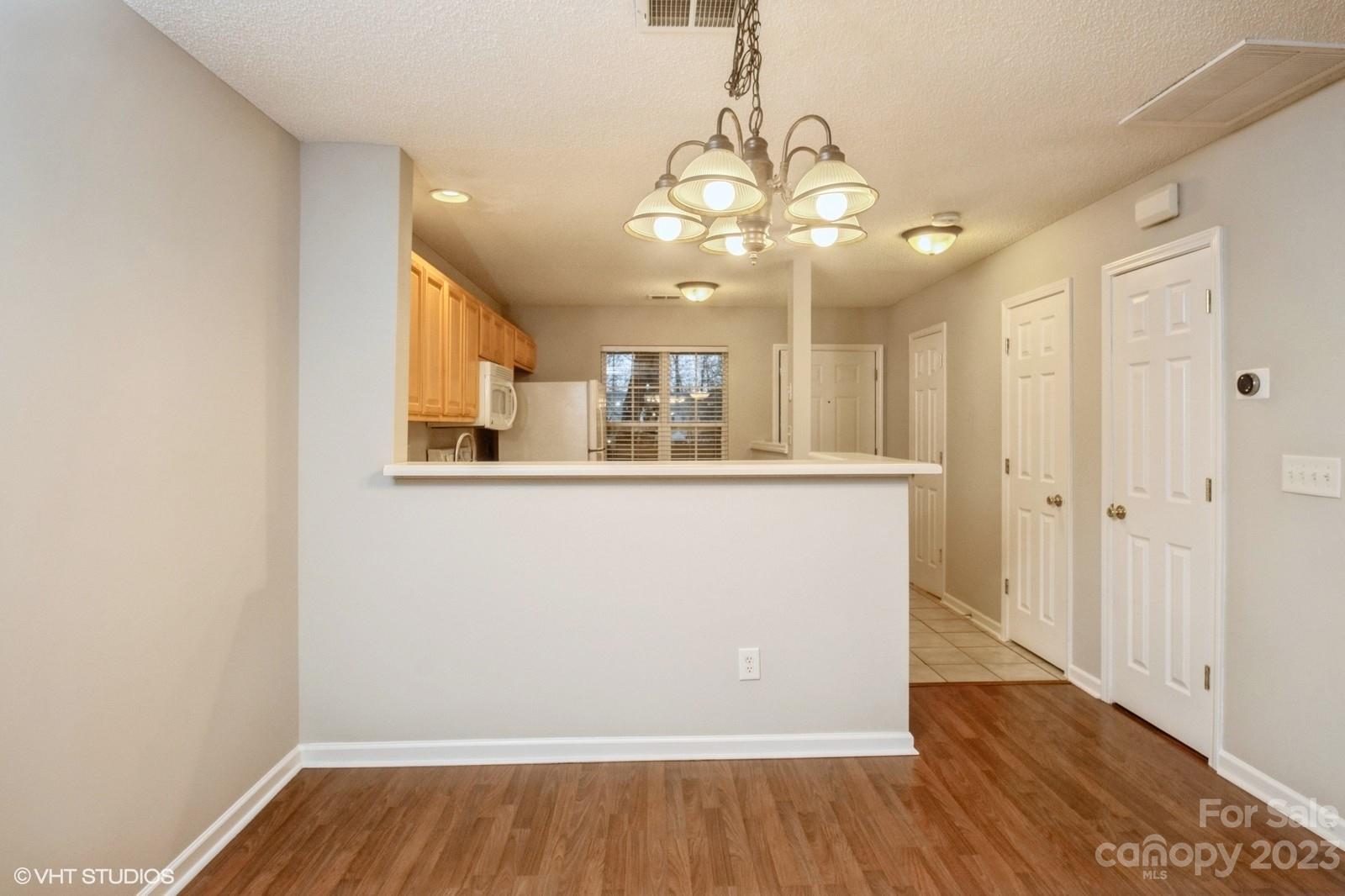 8334 Rudolph Road Charlotte, NC 28216 - Photo 7 of 31 a view of a room with wooden floor and chandelier