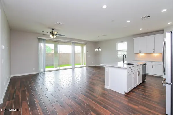 a large kitchen with stainless steel appliances a large counter top a sink a refrigerator and a window