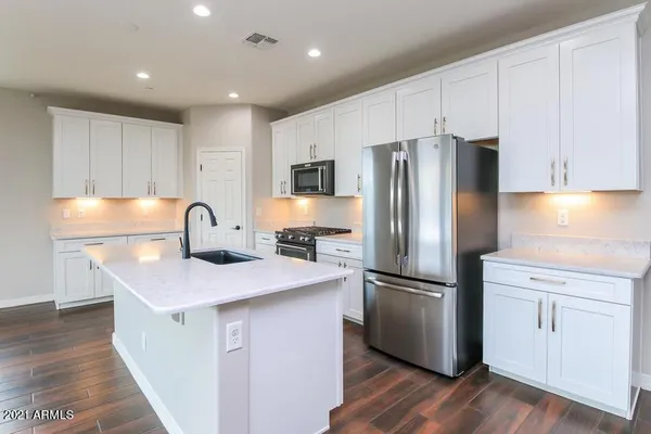 a kitchen with stainless steel appliances granite countertop a refrigerator a sink and a stove
