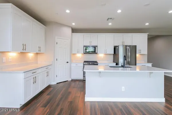 a kitchen with kitchen island white cabinets white stainless steel appliances and sink