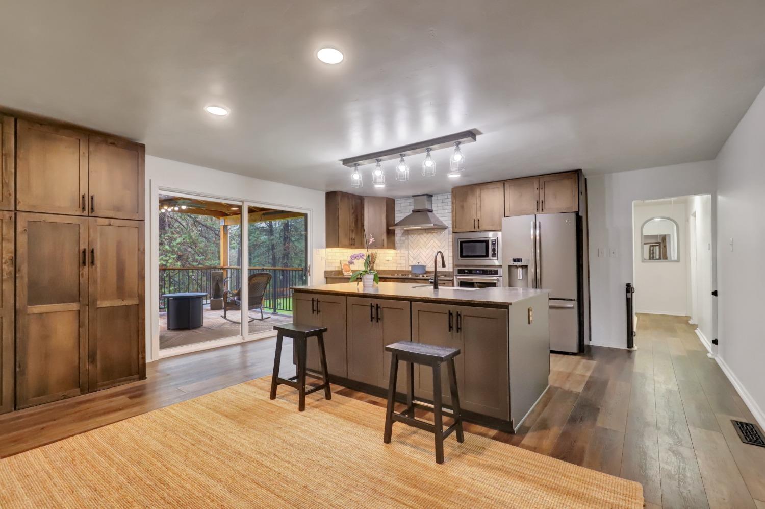 11625 Tyler Foote Road Nevada City, CA 95959 - Photo 11 of 96 a kitchen with stainless steel appliances kitchen island granite countertop a refrigerator a stove a sink dishwasher and white cabinets with wooden floor
