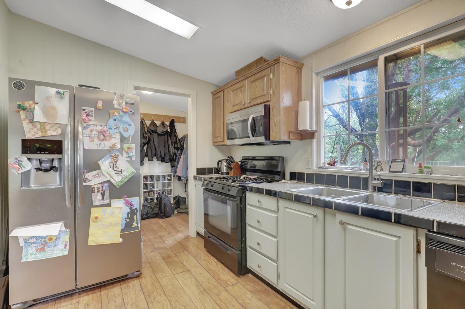 11625 Tyler Foote Road Nevada City, CA 95959 - Photo 45 of 96 a kitchen with stainless steel appliances granite countertop a stove top oven a sink dishwasher a refrigerator and cabinets with wooden floor