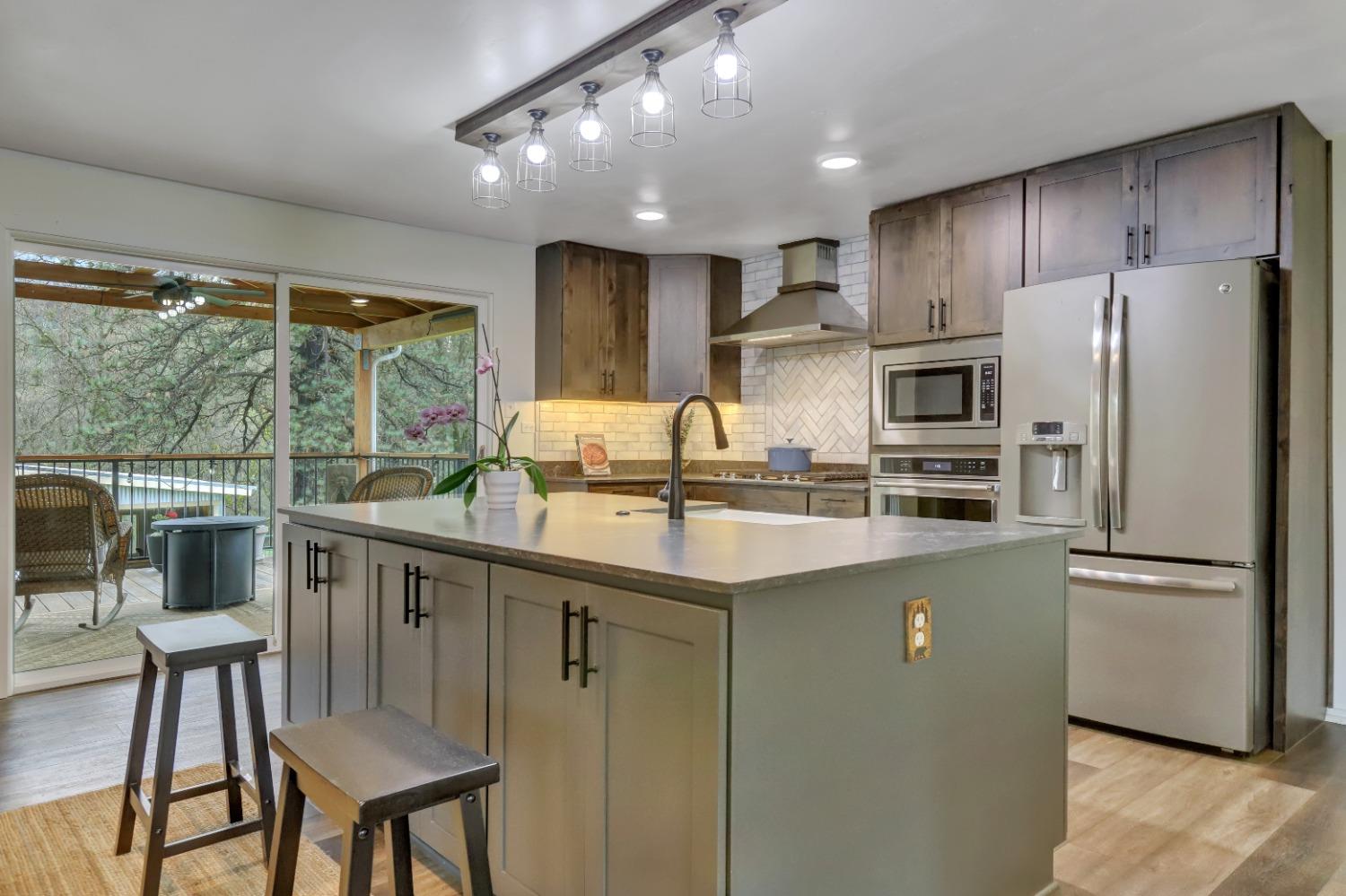 11625 Tyler Foote Road Nevada City, CA 95959 - Photo 10 of 96 a kitchen with stainless steel appliances granite countertop a refrigerator a stove a sink dishwasher a oven with white cabinets and wooden floor