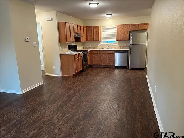 a kitchen with stainless steel appliances a refrigerator and a stove top oven