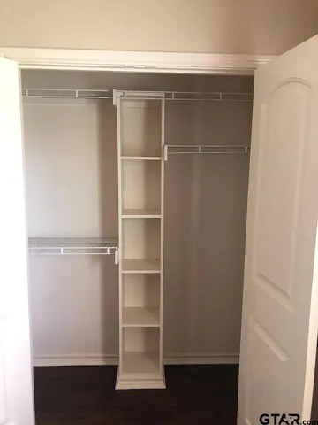 a view of walk in closet with empty racks