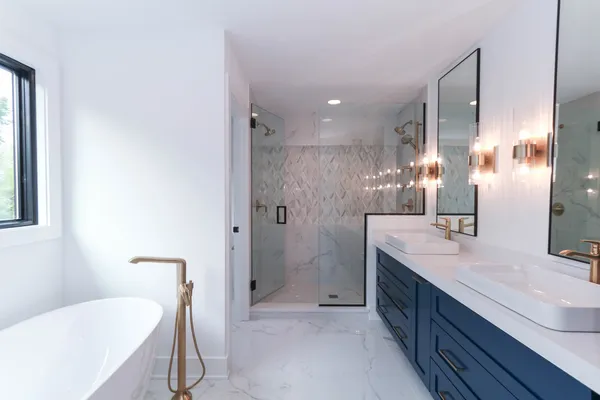 a bathroom with a double vanity sink toilet mirror and bathtub