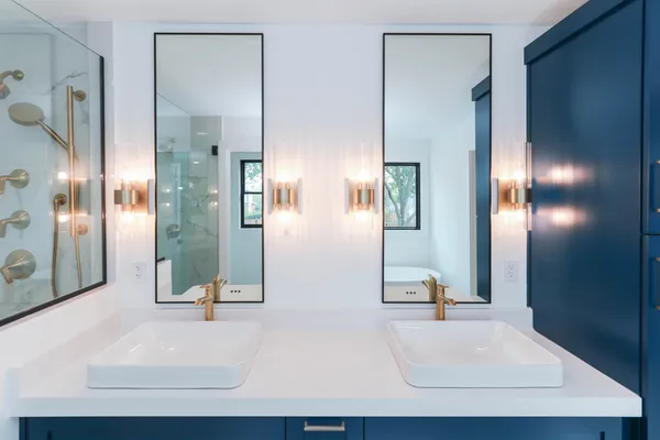 a bathroom with double vanity and a bathtub