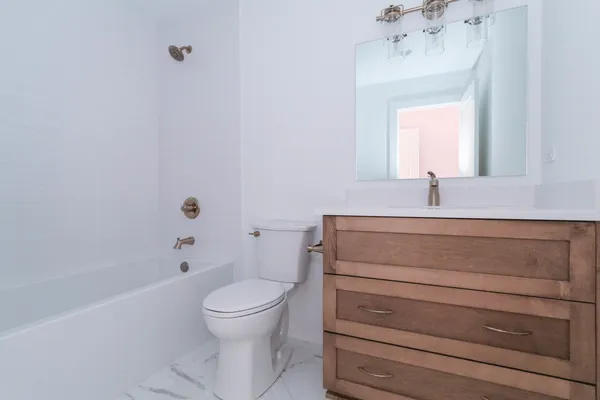 a bathroom with a sink a toilet and shower