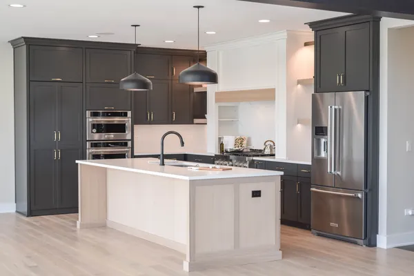 a kitchen with stainless steel appliances granite countertop a refrigerator a sink and a stove