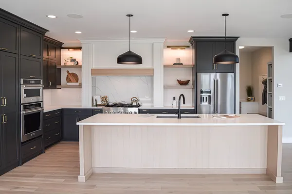 a large kitchen with stainless steel appliances granite countertop a sink a stove and a refrigerator