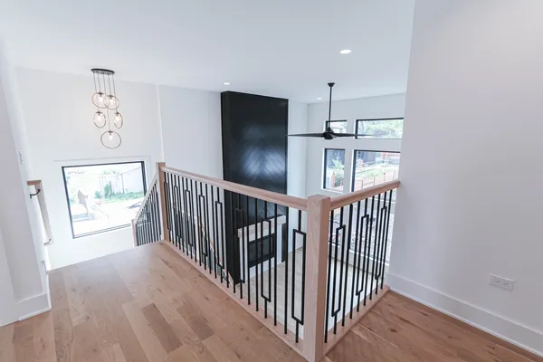 a view of hallway with wooden floor and windows