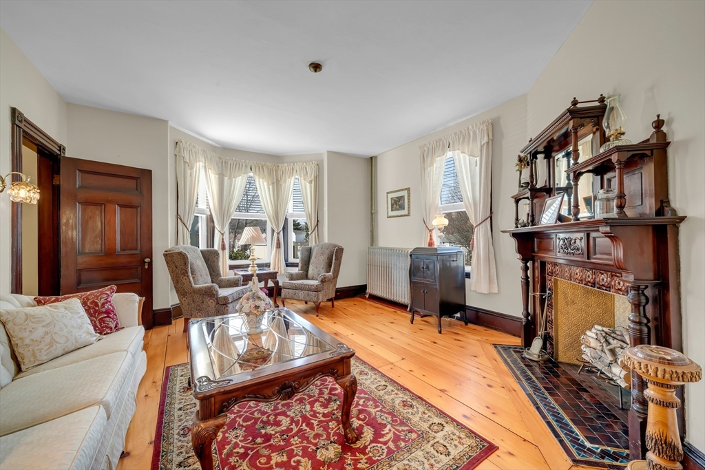 59 Washington Street Ipswich, MA 01938 - Photo 11 of 42 a living room with furniture a flat screen tv and a fireplace