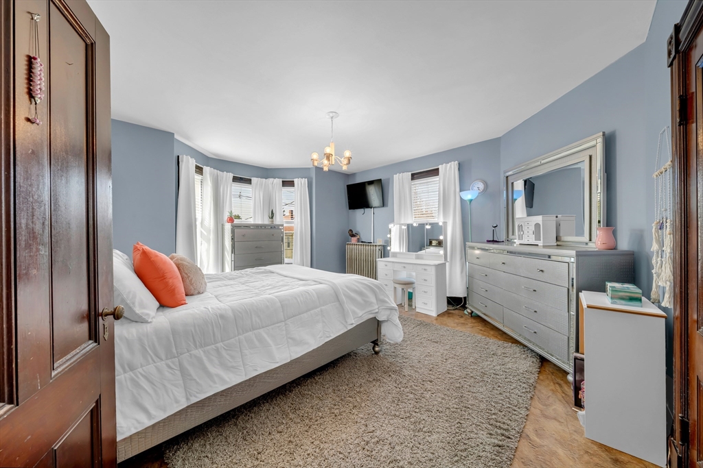 59 Washington Street Ipswich, MA 01938 - Photo 34 of 42 a bedroom with a bed and wooden floor