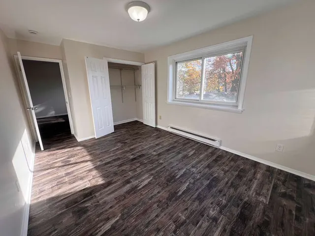 a view of a room with wooden floor and window