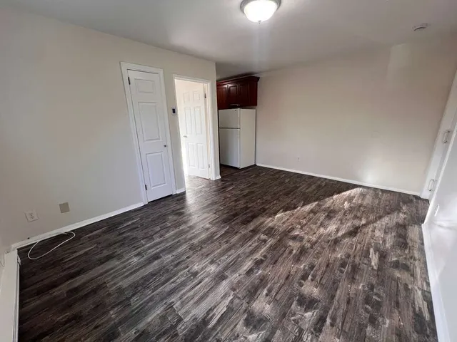 a view of an empty room with a fireplace and cabinets