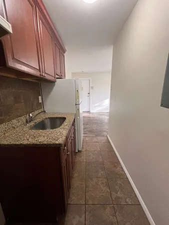 a kitchen with granite countertop a sink a stove and cabinets