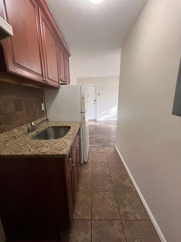 a kitchen with granite countertop a sink a stove and cabinets