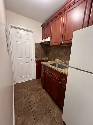 a kitchen with a refrigerator sink stove and cabinets