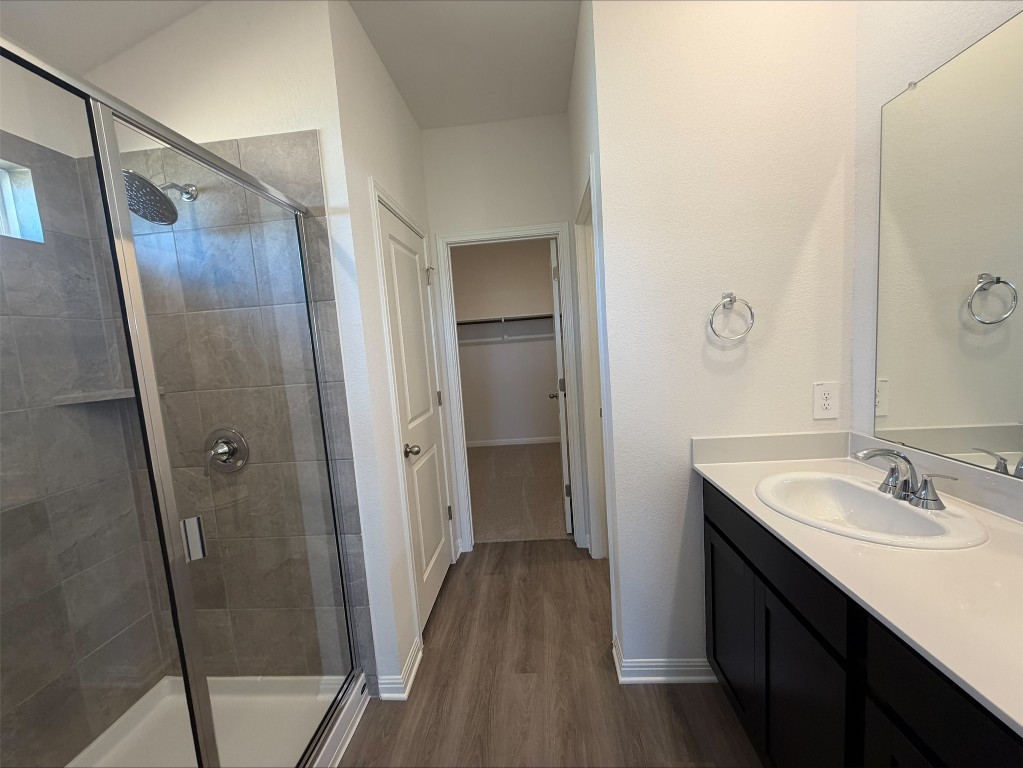 113 Honey Bee Road Jarrell, TX 76537 - Photo 10 of 10 Bathroom featuring vanity, a spacious closet, a shower stall, and dark wood finished floors