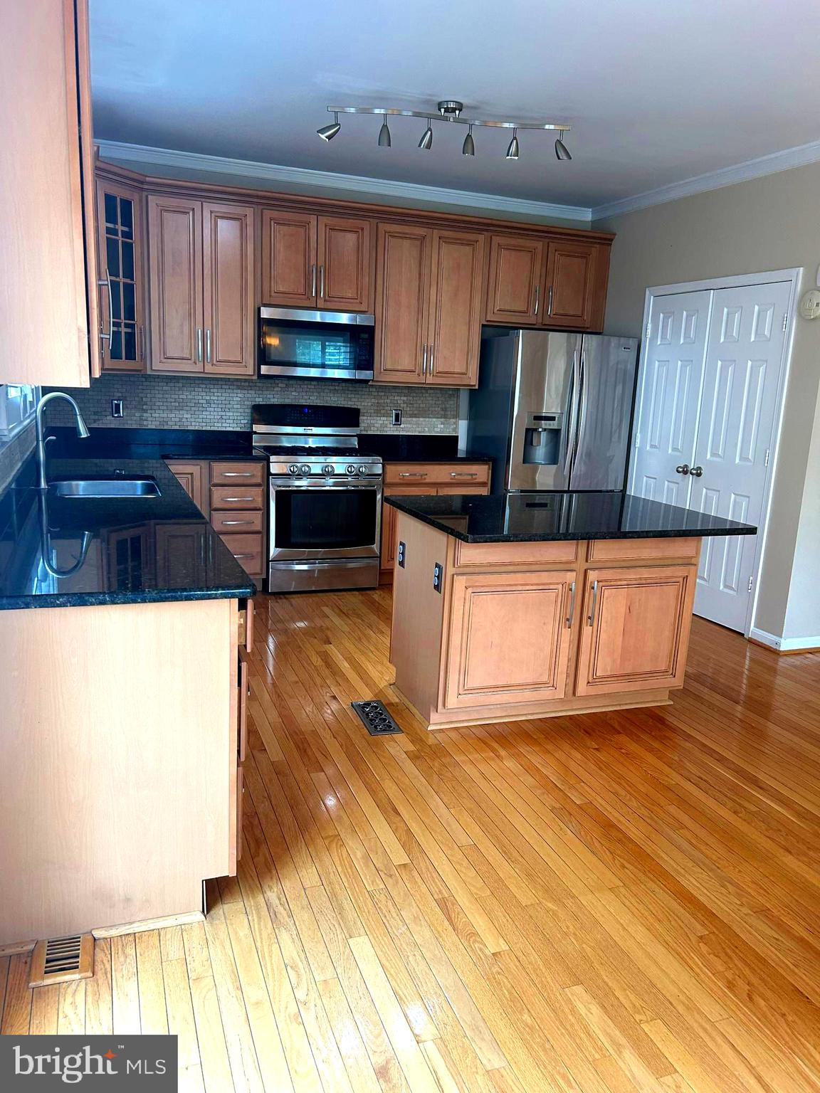 4658 Buckhorn Ridge Fairfax, VA 22030 - Photo 5 of 35 a kitchen with granite countertop wood cabinets stainless steel appliances and a window