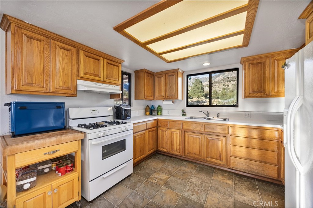 9990 Fay Ranch Road Weldon, CA 93283 - Photo 27 of 51 a kitchen with stainless steel appliances granite countertop a stove sink and cabinets