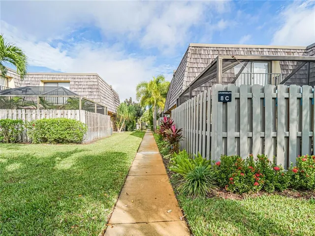 a pathway with a white house in front of main door