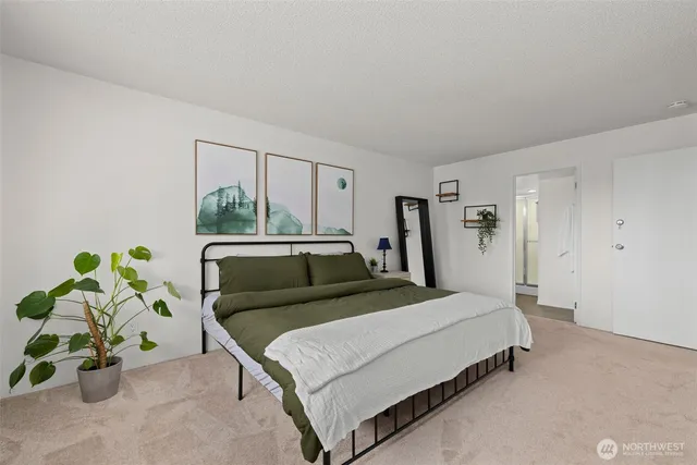 a bedroom with a bed table and a potted plant