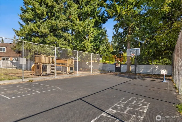 a view of a roof deck with wooden fence and a bench