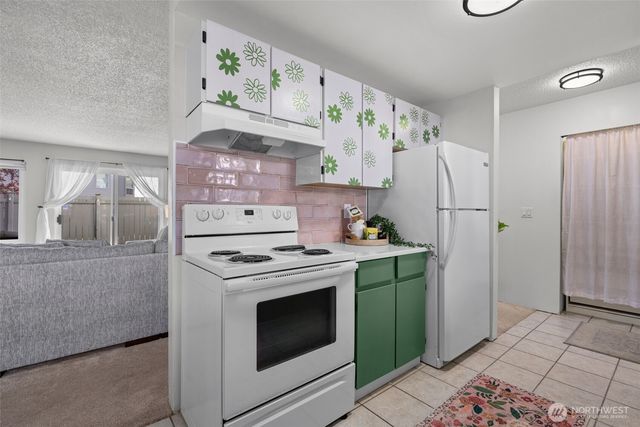 a kitchen with stainless steel appliances a stove a refrigerator and cabinets