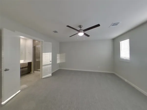 an empty room with closet and windows